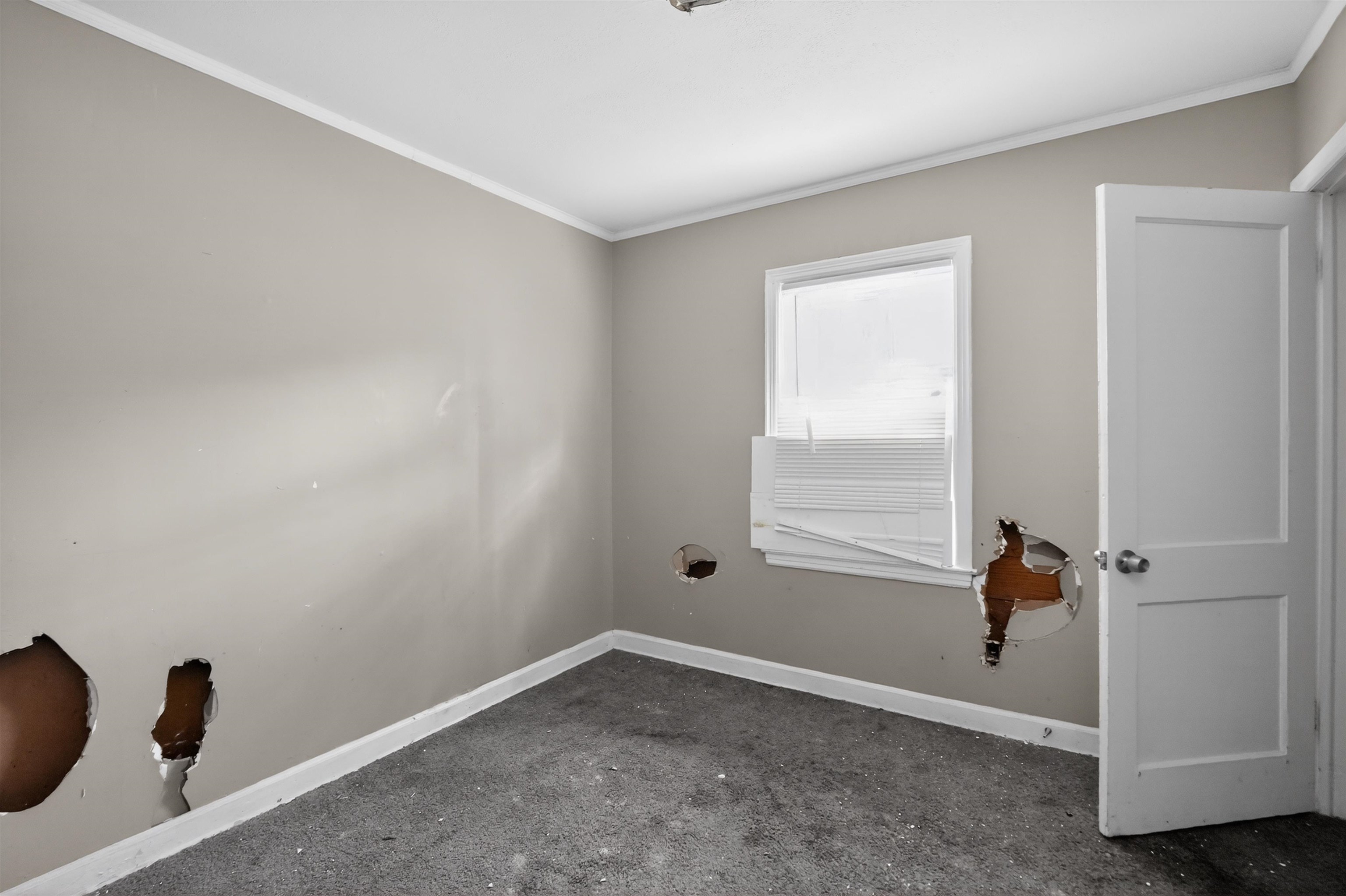 949 Sumter Street Memphis, TN 38122 - Photo 19 of 33 Room featuring light grey painted walls with white trim, a white window frame, and a white interior door with a silver-toned doorknob
