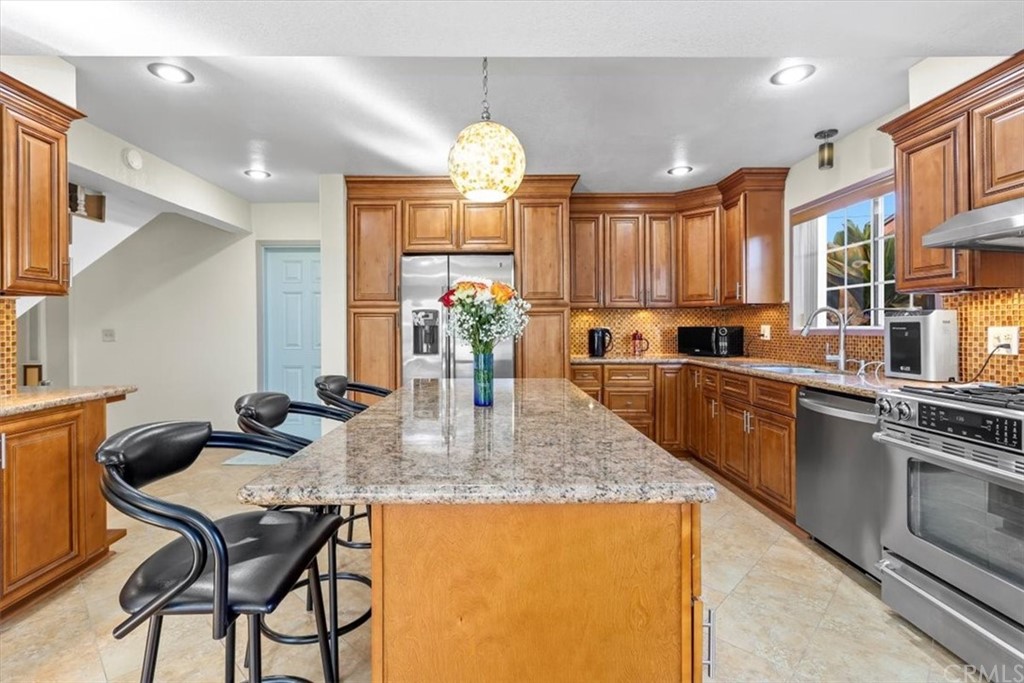 302 East 213th Street Carson, CA 90745 - Photo 7 of 41 a kitchen with granite countertop a stove a sink a counter space and dining table