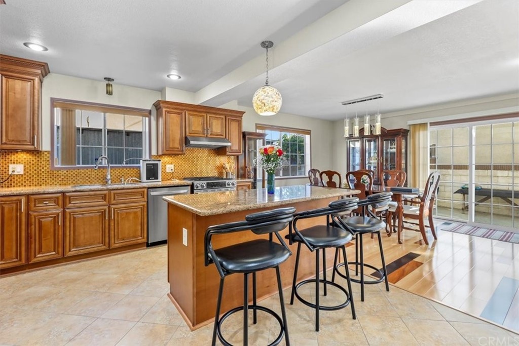 302 East 213th Street Carson, CA 90745 - Photo 10 of 41 a kitchen with stainless steel appliances a table and chairs in it
