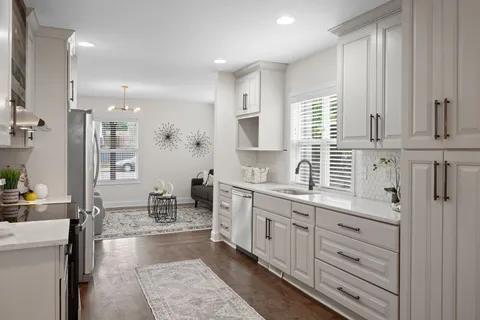 a kitchen with kitchen island granite countertop a sink cabinets and window