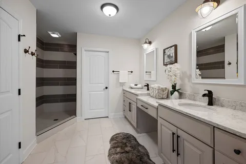 a en suite bathroom with a double vanity sink a mirror and a shower