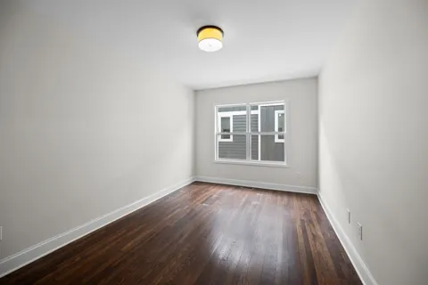 a view of a room with wooden floor and window