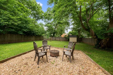 a view of a chairs and table in backyard of the house