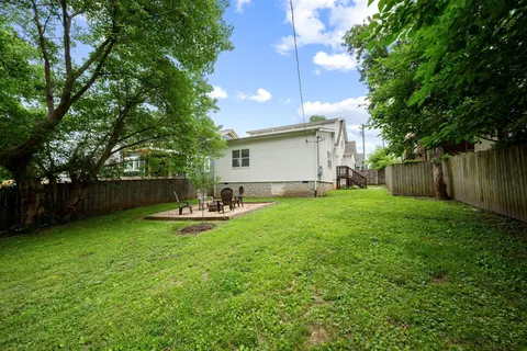 a view of a backyard with table and chairs and wooden fence