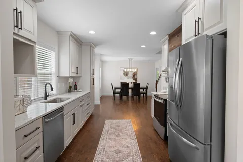 a kitchen with stainless steel appliances a refrigerator sink and cabinets