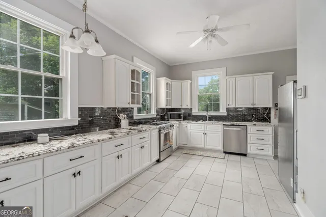 a bedroom with a large bed chandelier and a window