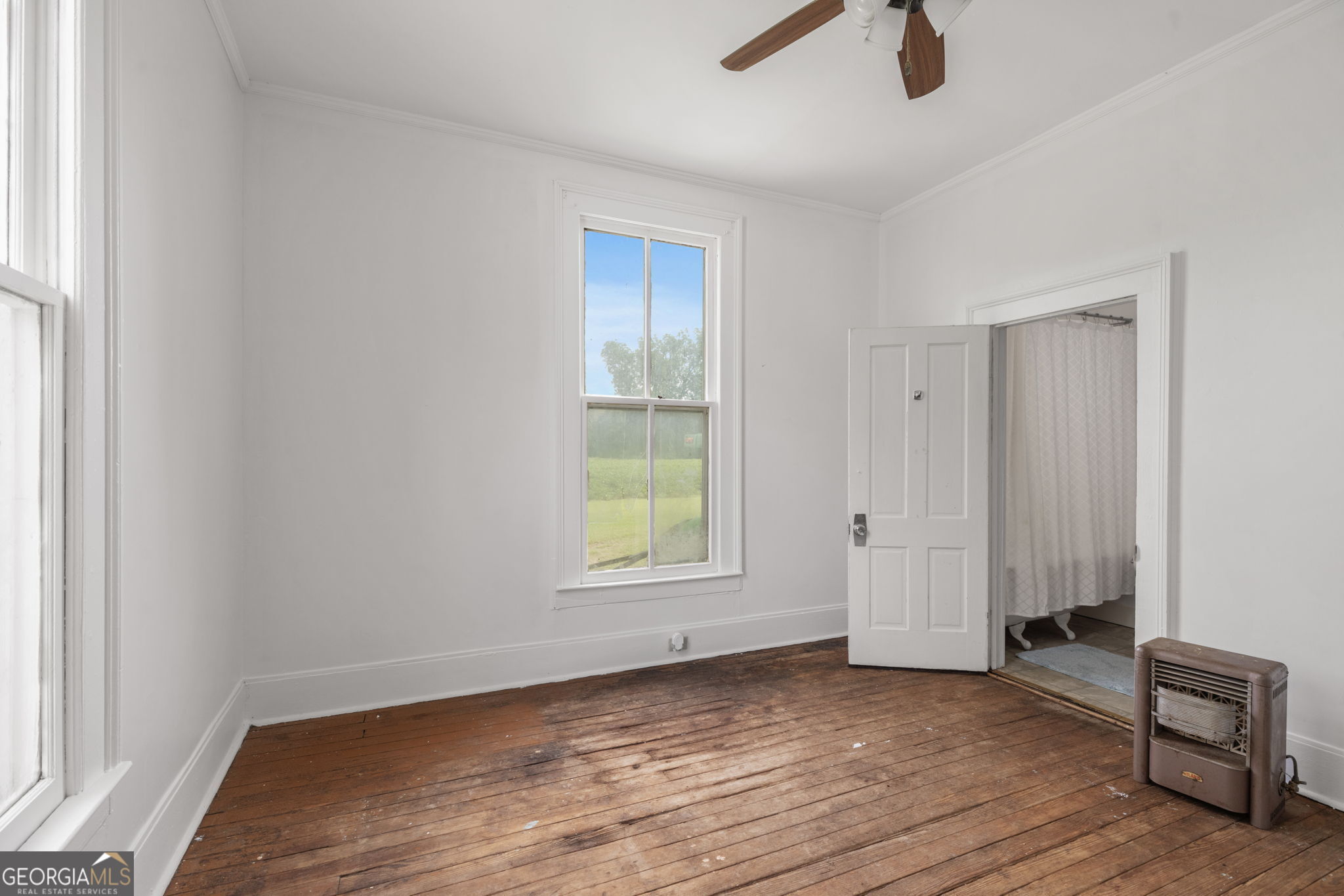 7890 Poplar Springs Road Byromville, GA 31007 - Photo 28 of 74 an empty room with wooden floor cabinet and windows