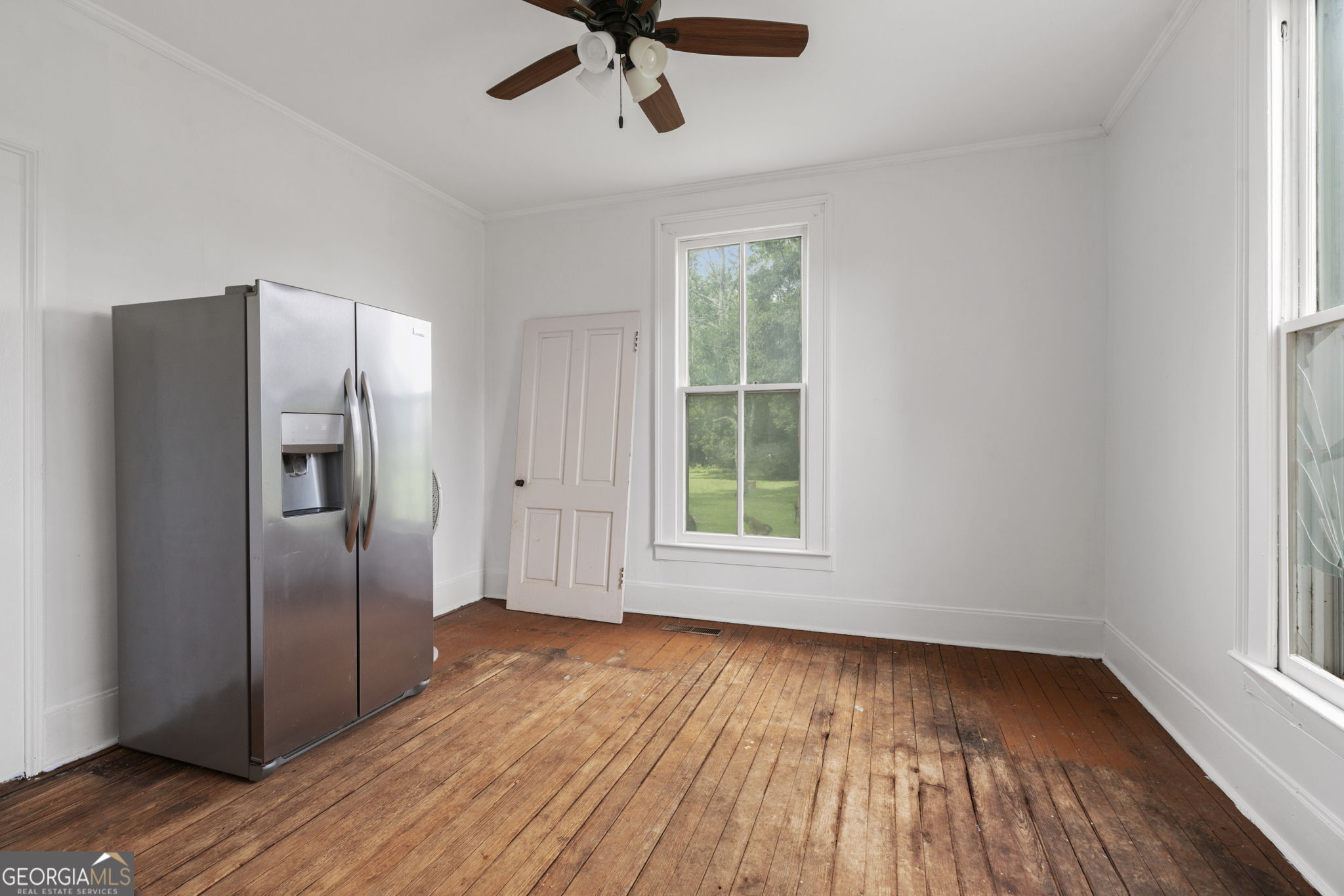 7890 Poplar Springs Road Byromville, GA 31007 - Photo 29 of 74 a view of an empty room with wooden floor fridge and a window