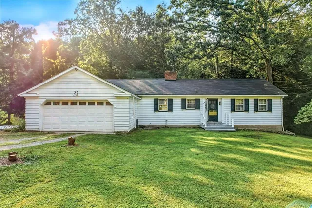 a view of a house with a yard and fence