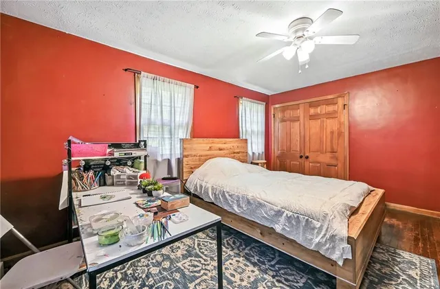 a bed sitting in a spacious bedroom next to a window