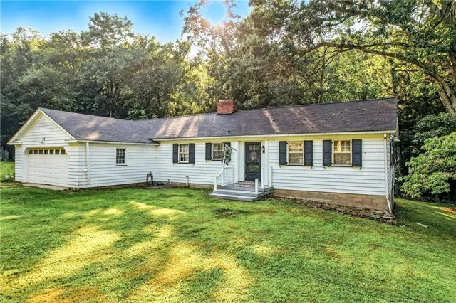 a view of a house with a yard and sitting area