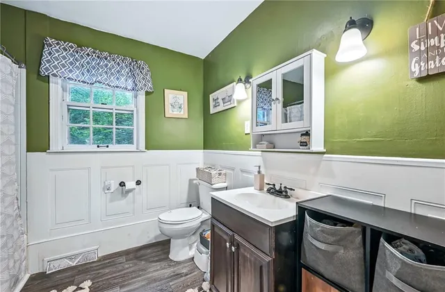 a bathroom with a sink a toilet and mirror