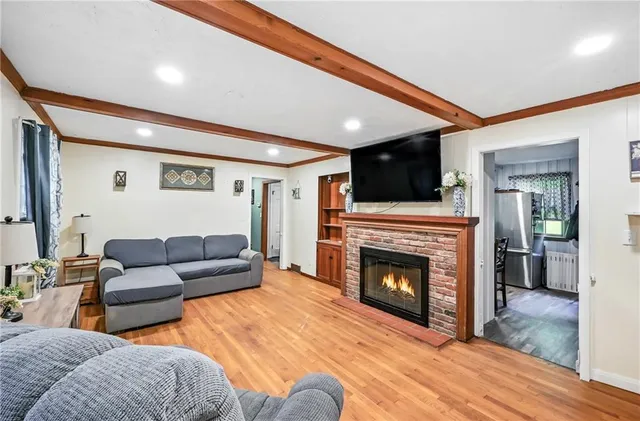 a living room with furniture a flat screen tv and a fireplace