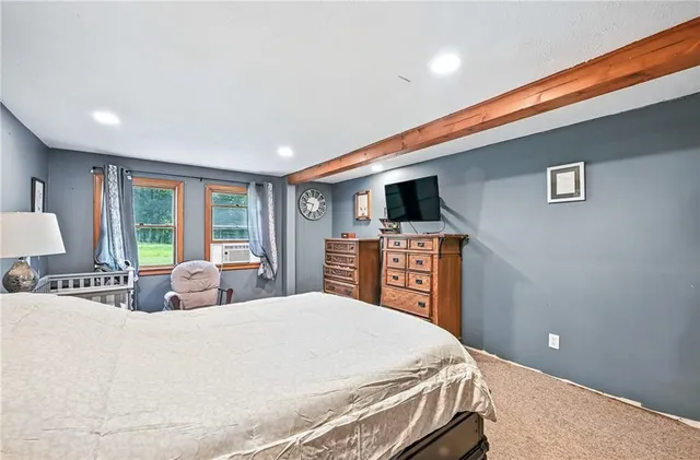 a bed sitting in a spacious bedroom next to a window