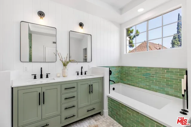 a bathroom with a double vanity sink mirror and bathtub