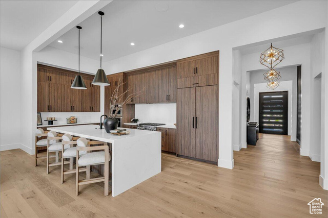 2761 West Lava Hls Road Santa Clara, UT 84765 - Photo 5 of 53 Kitchen with pendant lighting, a breakfast bar area, a center island with sink, light stone counters, and recessed lighting