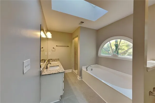 a bathroom with a tub sink and mirror