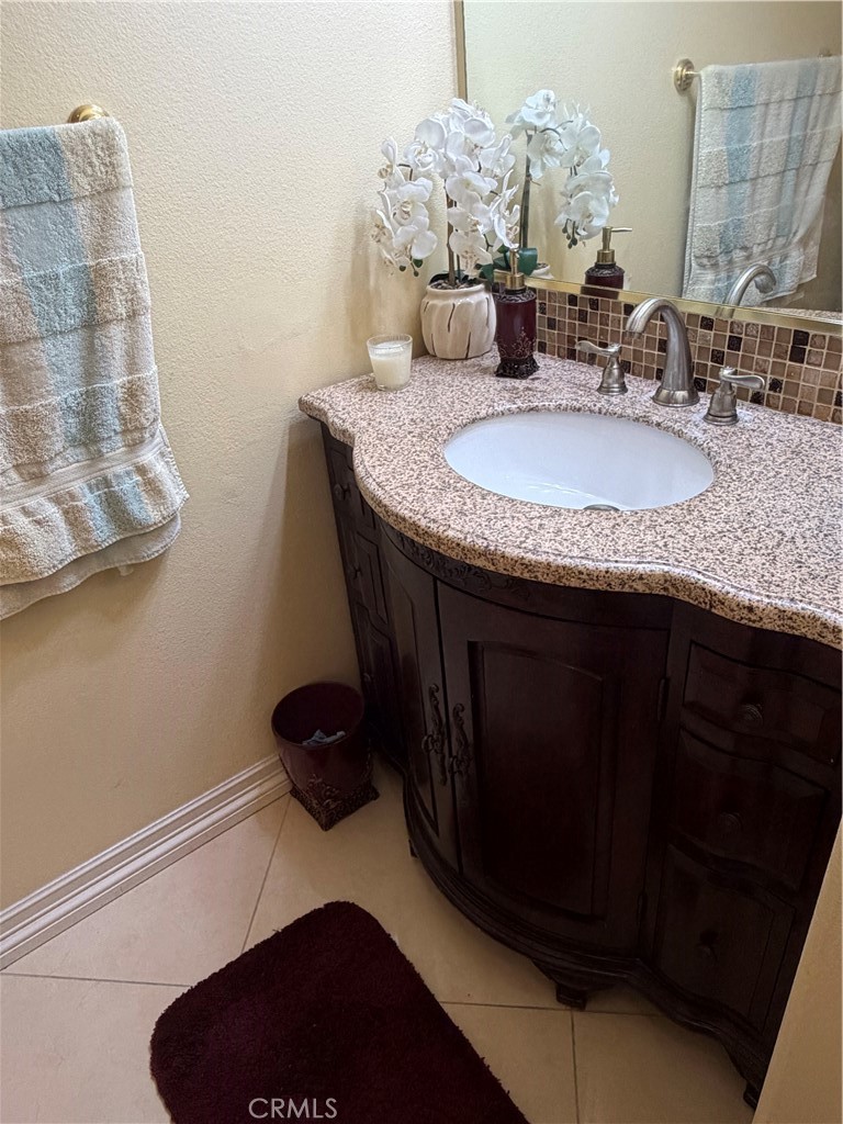 19823 Mariposa Pines Way Porter Ranch, CA 91326 - Photo 35 of 50 a bathroom with a granite countertop sink a mirror and vanity