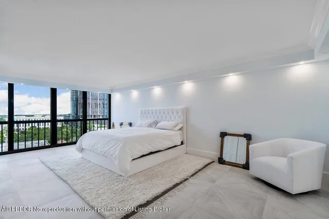 a large white bed sitting in a bedroom next to a lamp