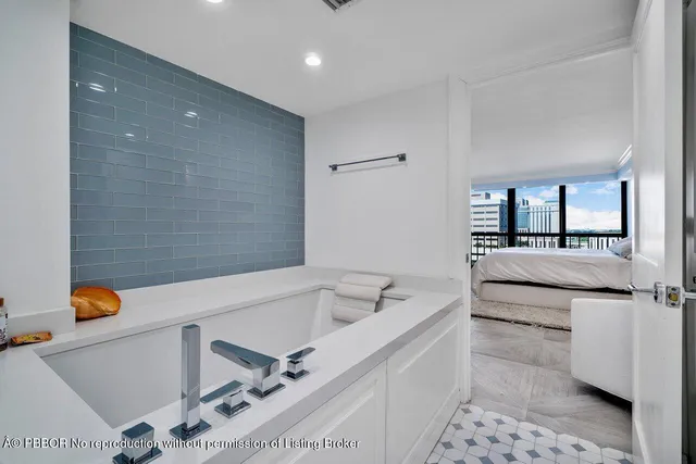 a bathroom with a tub sink and mirror