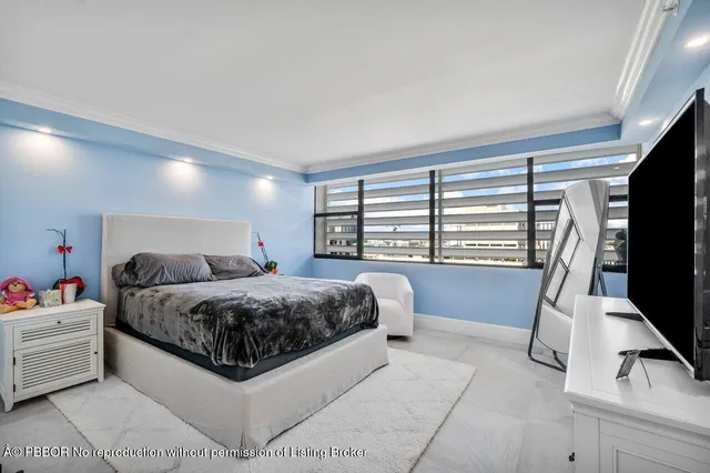 a spacious bedroom with a bed and a flat screen tv