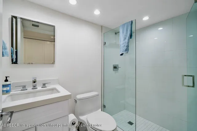 a bathroom with a toilet sink vanity and shower