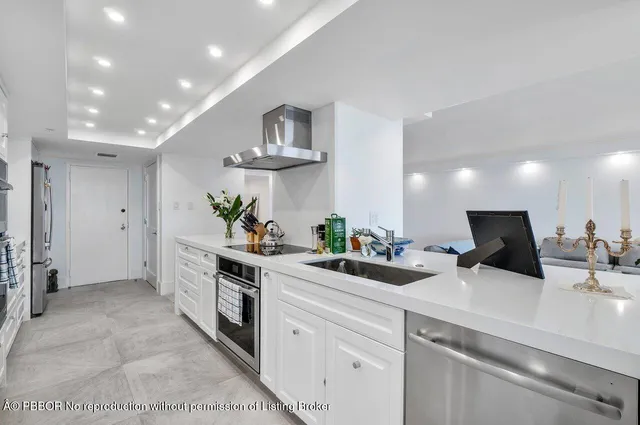 a kitchen with stainless steel appliances a sink a stove a refrigerator and cabinets