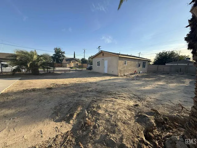 a view of a dry yard with wooden fence