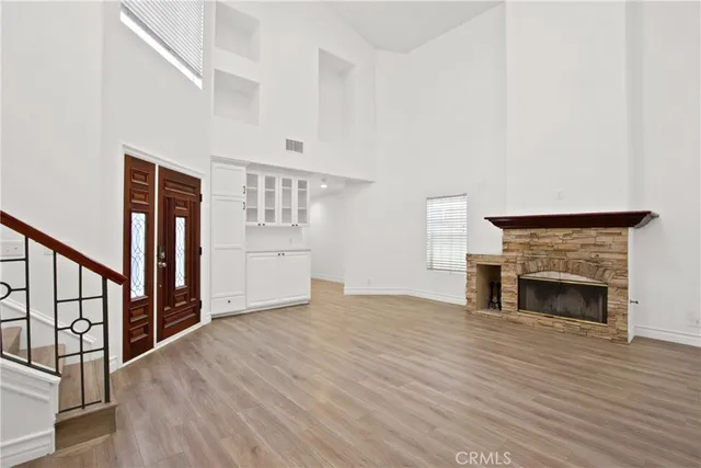 a view of empty room with fireplace and wooden floor