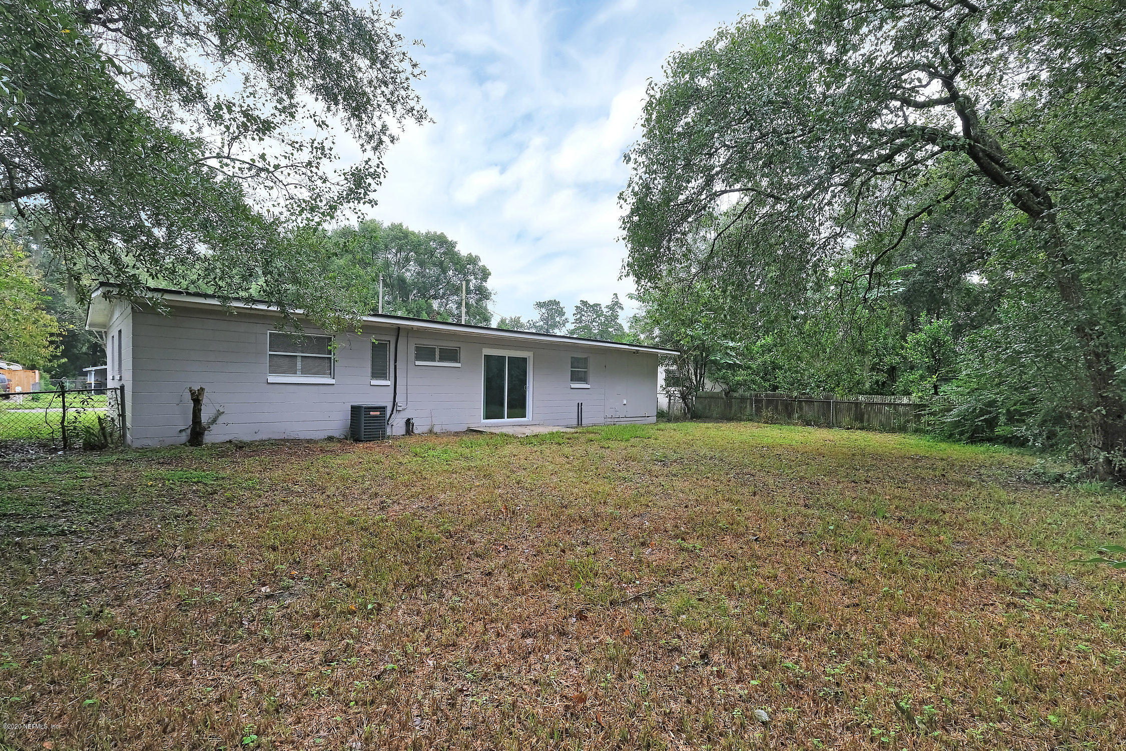 7504 Proxima Road Jacksonville, FL 32210 - Photo 24 of 24 a backyard of a house with large trees and a barn
