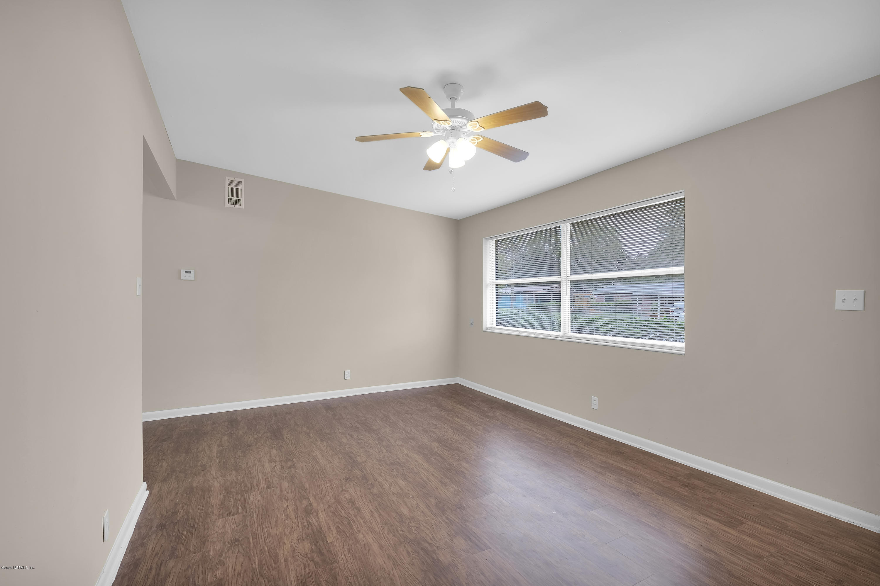 7504 Proxima Road Jacksonville, FL 32210 - Photo 5 of 24 a view of an empty room with window and wooden floor