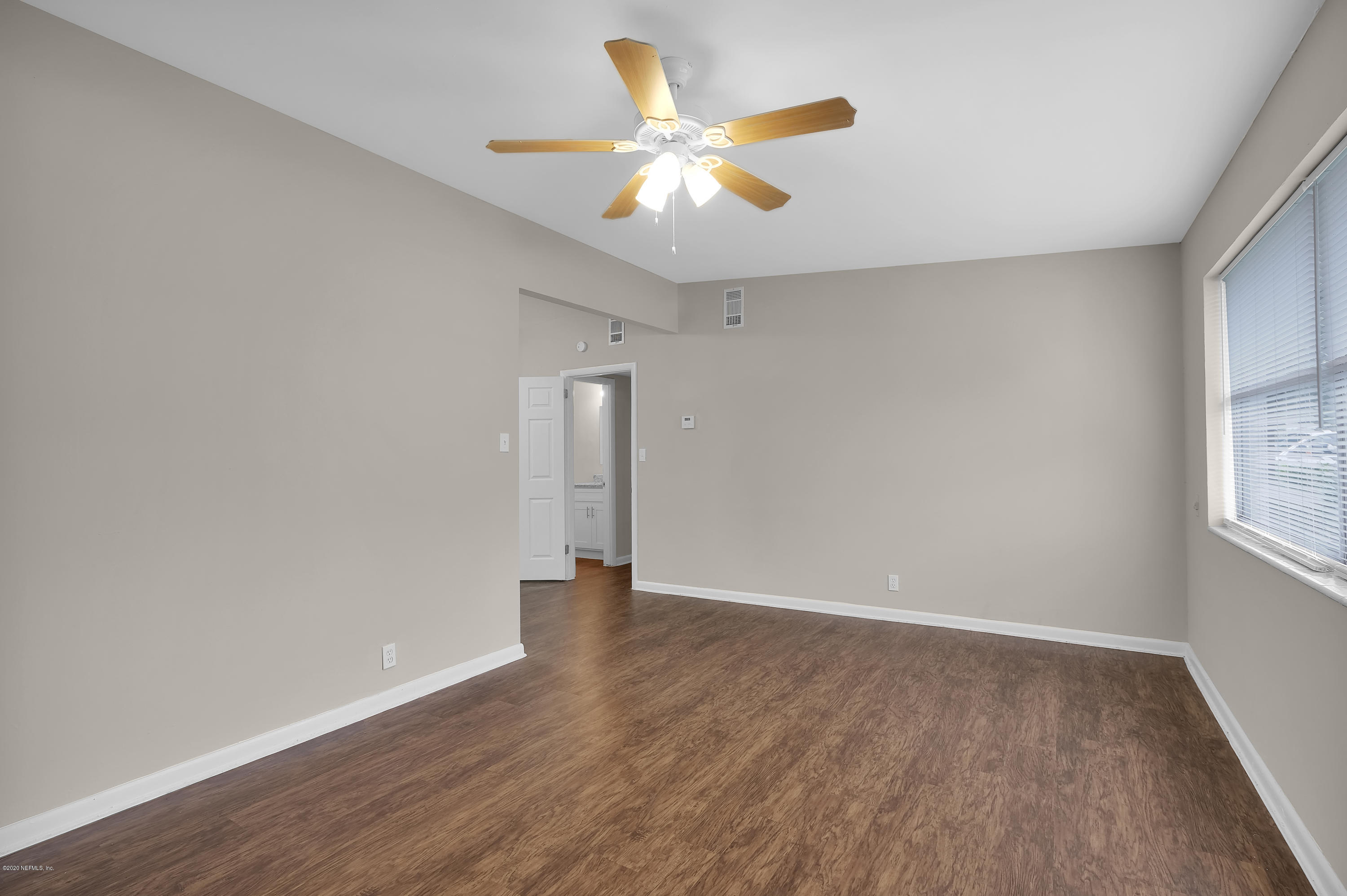 7504 Proxima Road Jacksonville, FL 32210 - Photo 7 of 24 wooden floor in an empty room with a window