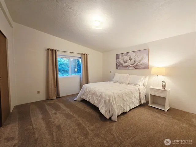 a bedroom with a bed and a painting on the wall