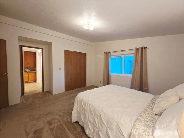 a bedroom with a large bed and a chandelier