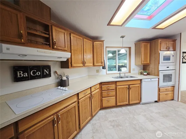 a kitchen with stainless steel appliances granite countertop a stove a sink and a microwave
