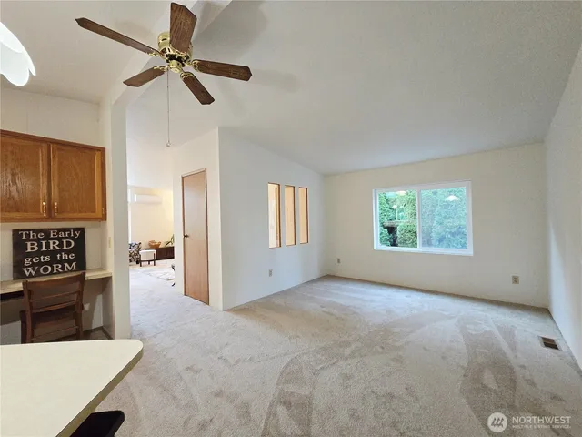 a view of a room with a ceiling fan and window