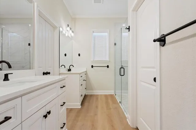 a spacious bathroom with a double vanity sink mirror and shower