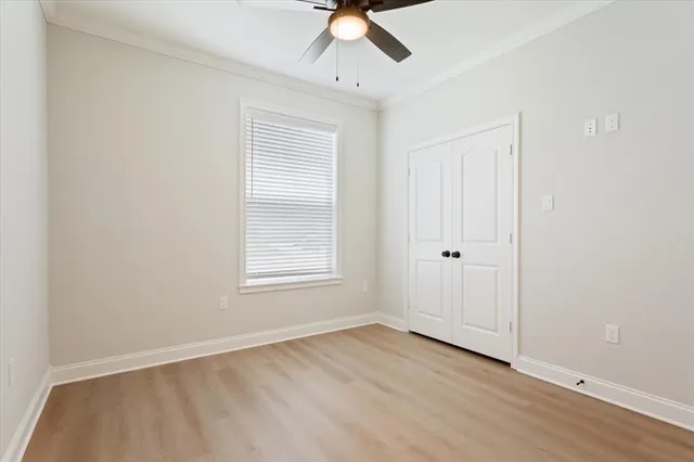 an empty room with a window and a ceiling fan