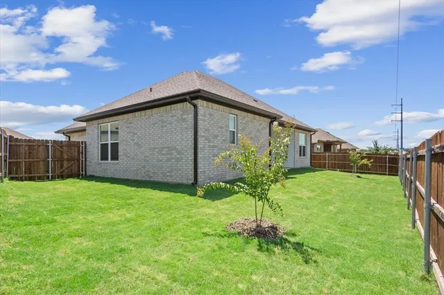 a backyard of a house with plants and wooden fence