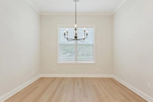 an empty room with a window and chandelier