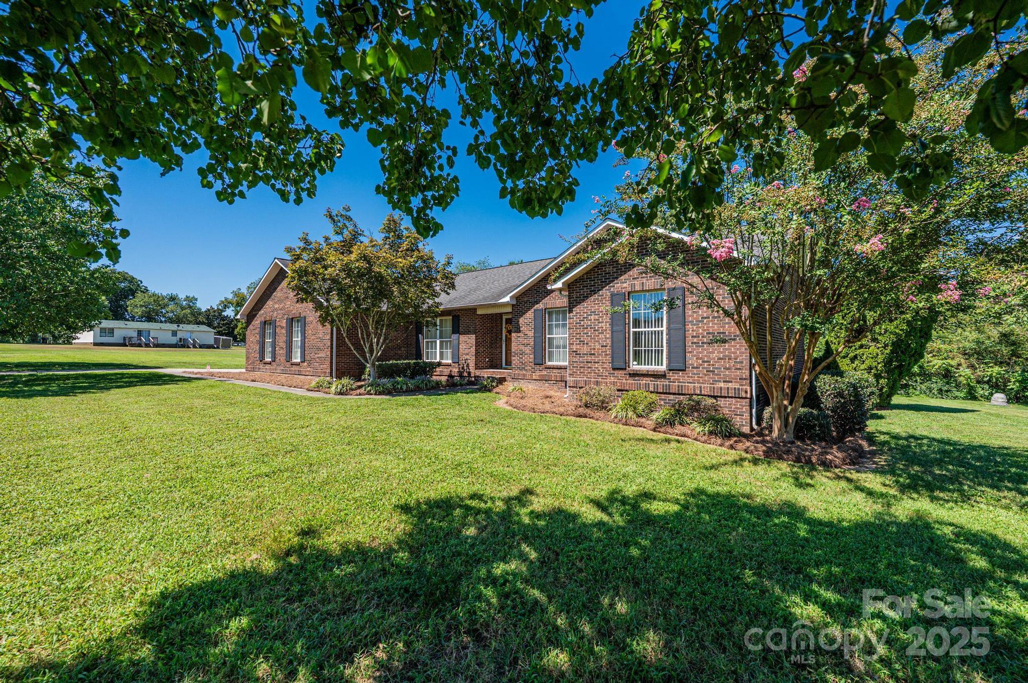 227 Robert Keever Road Stanley, NC 28164 - Photo 2 of 45 a house with green field in front of it