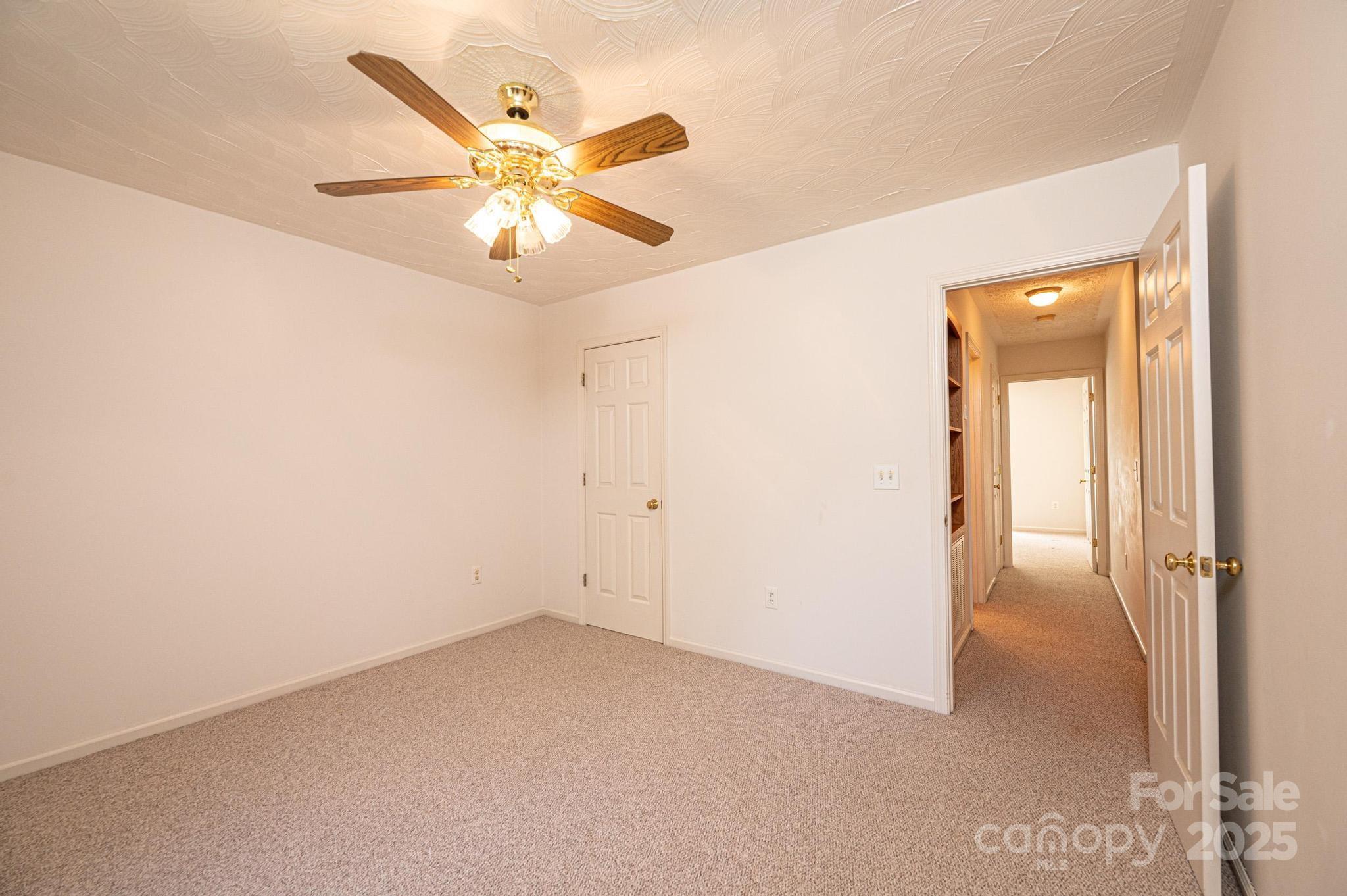 227 Robert Keever Road Stanley, NC 28164 - Photo 40 of 45 an empty room with closet and a chandelier fan