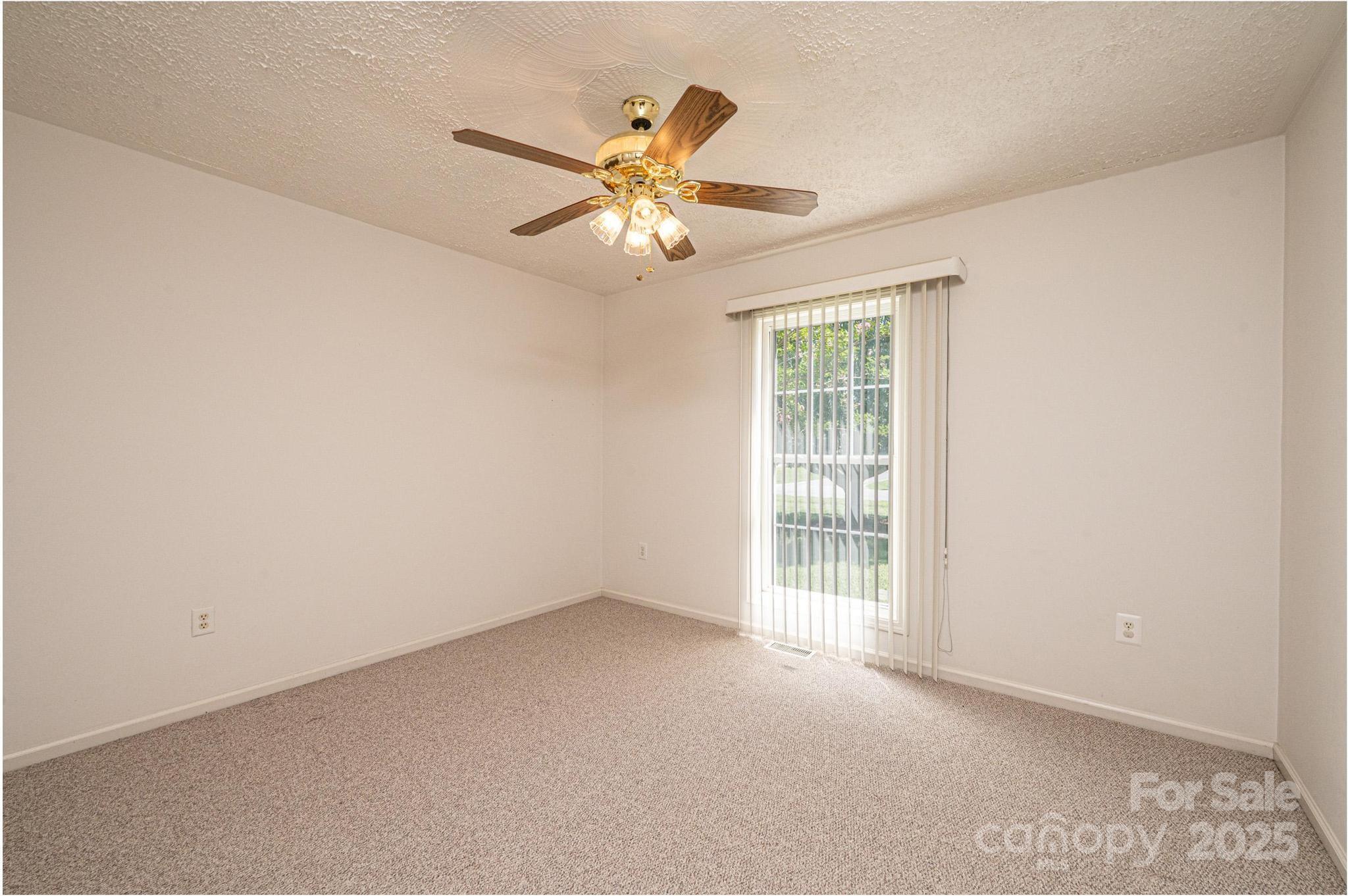 227 Robert Keever Road Stanley, NC 28164 - Photo 43 of 45 an empty room with windows and fan