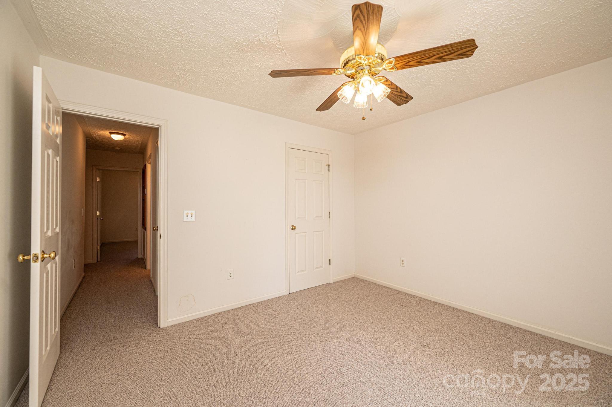 227 Robert Keever Road Stanley, NC 28164 - Photo 44 of 45 an empty room with a chandelier fan and closet