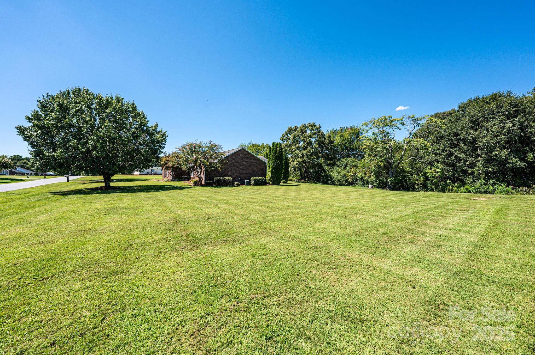 227 Robert Keever Road Stanley, NC 28164 - Photo 5 of 45 a view of a green field with trees in the background