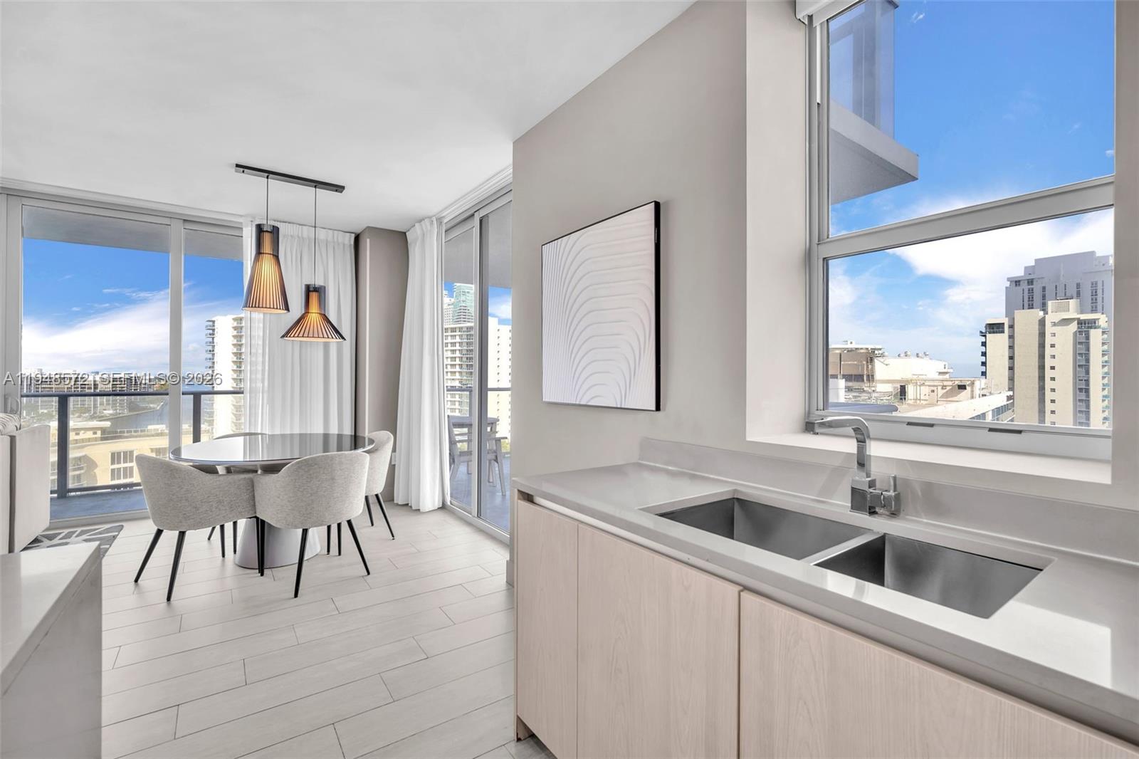 4010 South Ocean Drive, Unit R701 Hollywood, FL 33019 - Photo 12 of 46 a kitchen with a table chairs sink and cabinets