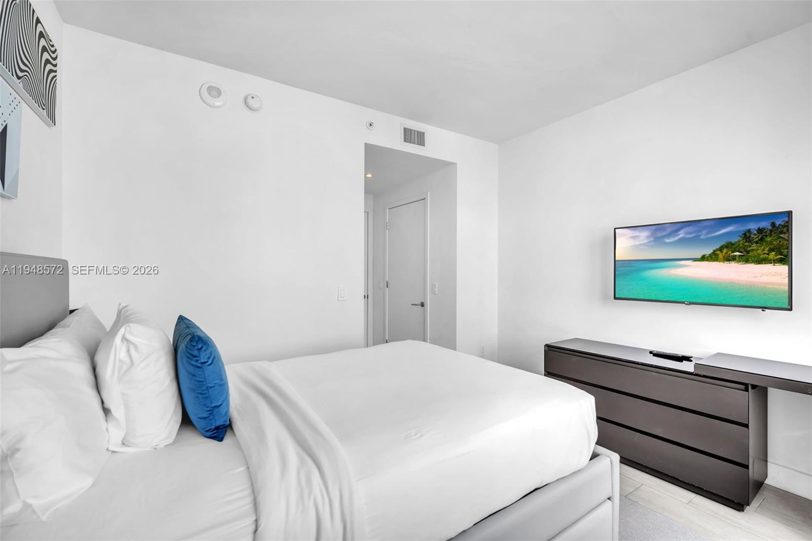 4010 South Ocean Drive, Unit R701 Hollywood, FL 33019 - Photo 18 of 46 a bedroom with a bed and a flat screen tv