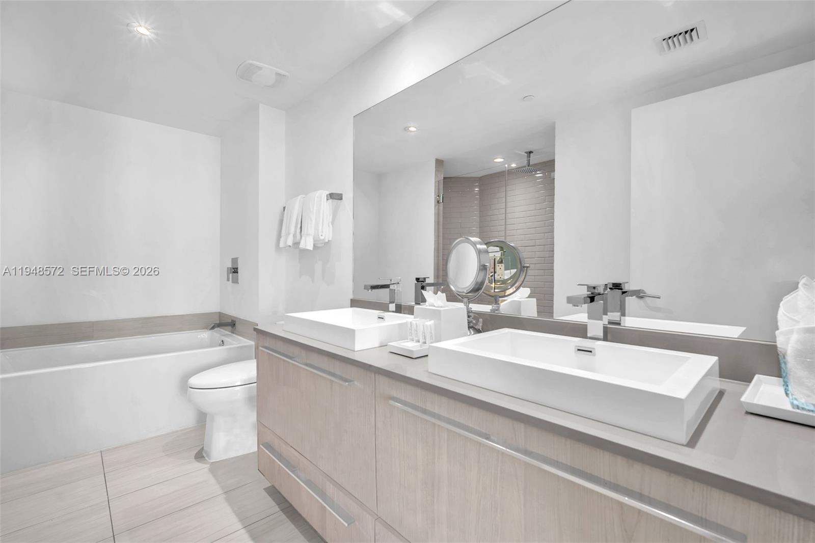 4010 South Ocean Drive, Unit R701 Hollywood, FL 33019 - Photo 25 of 46 a bathroom with a double vanity sink toilet and a bathtub