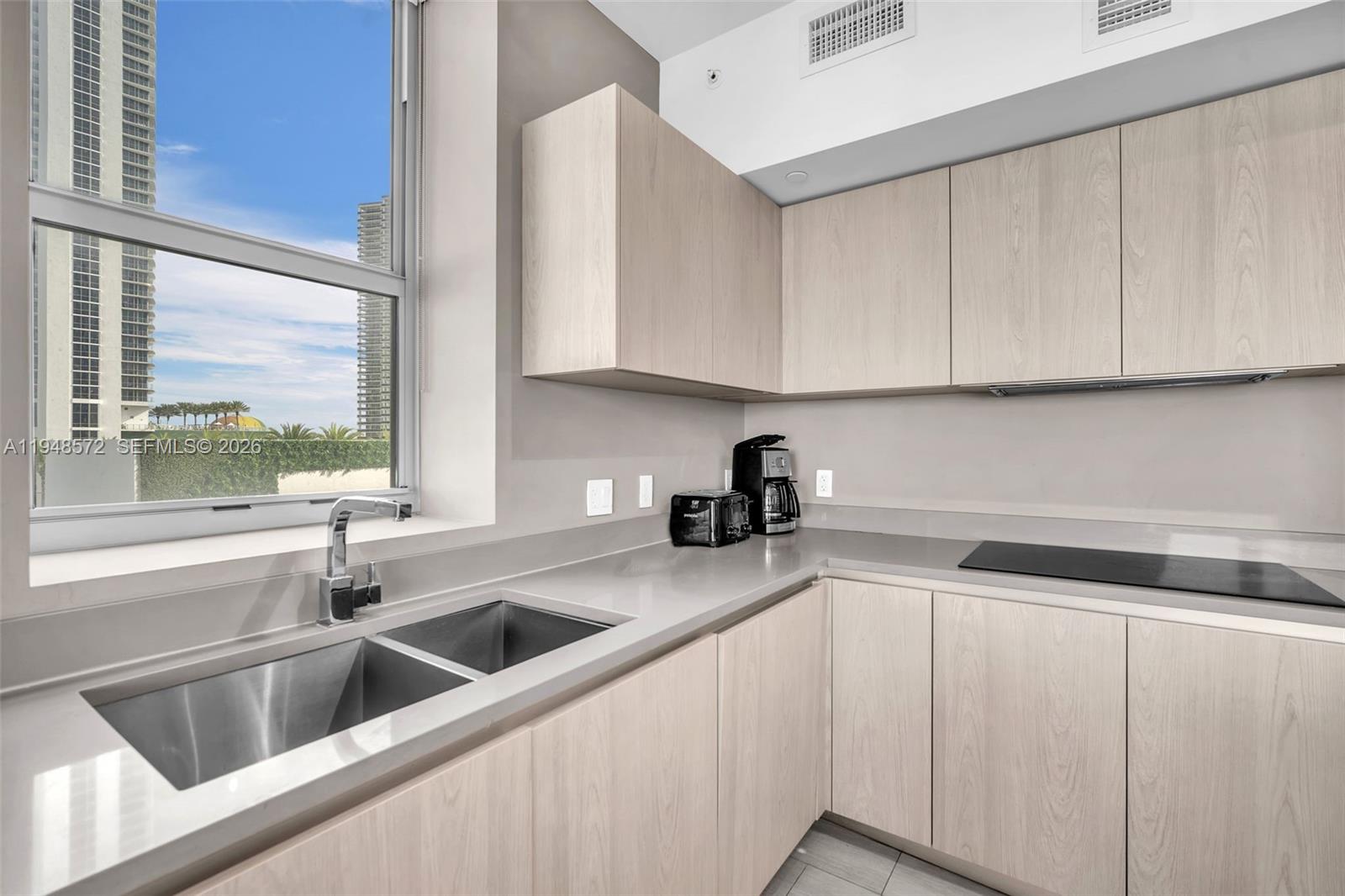4010 South Ocean Drive, Unit R701 Hollywood, FL 33019 - Photo 10 of 46 a kitchen with stainless steel appliances granite countertop a sink and a white cabinets