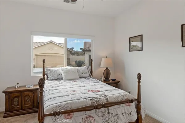 a bedroom with a bed and a potted plant on the dresser